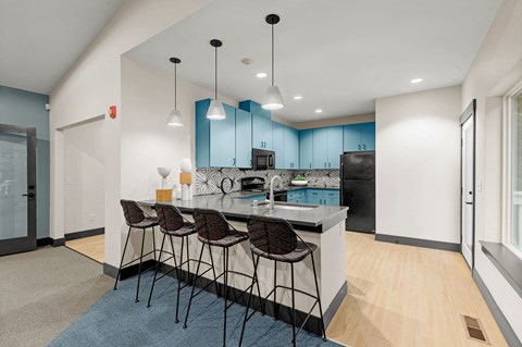 a kitchen with blue cabinets and a counter with chairs