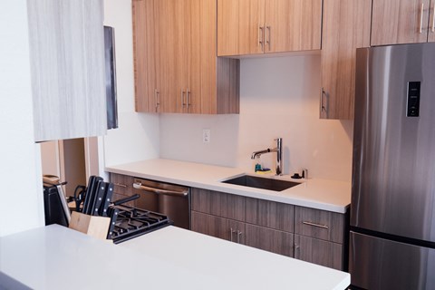 a kitchen with white counter top and wooden cabinets
