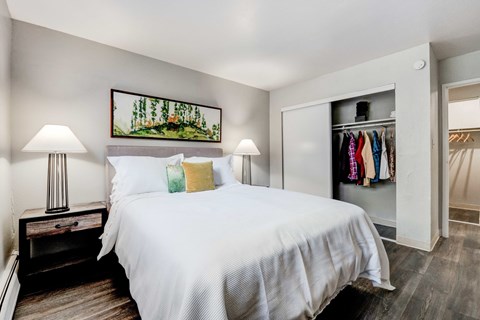 A bedroom with a large bed and a painting above it.