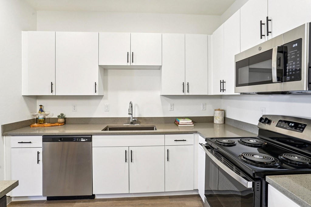 A modern kitchen with white cabinets and stainless steel appliances.at Cottonwood Ranch, Casa Grande
