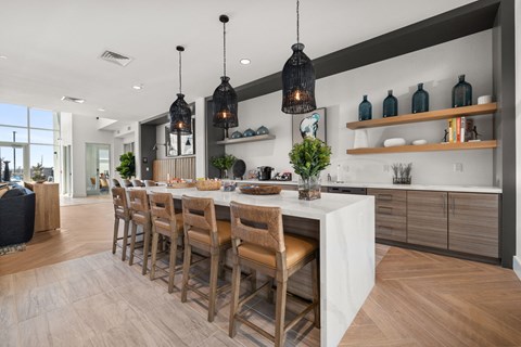 A kitchen with a long table and chairs.