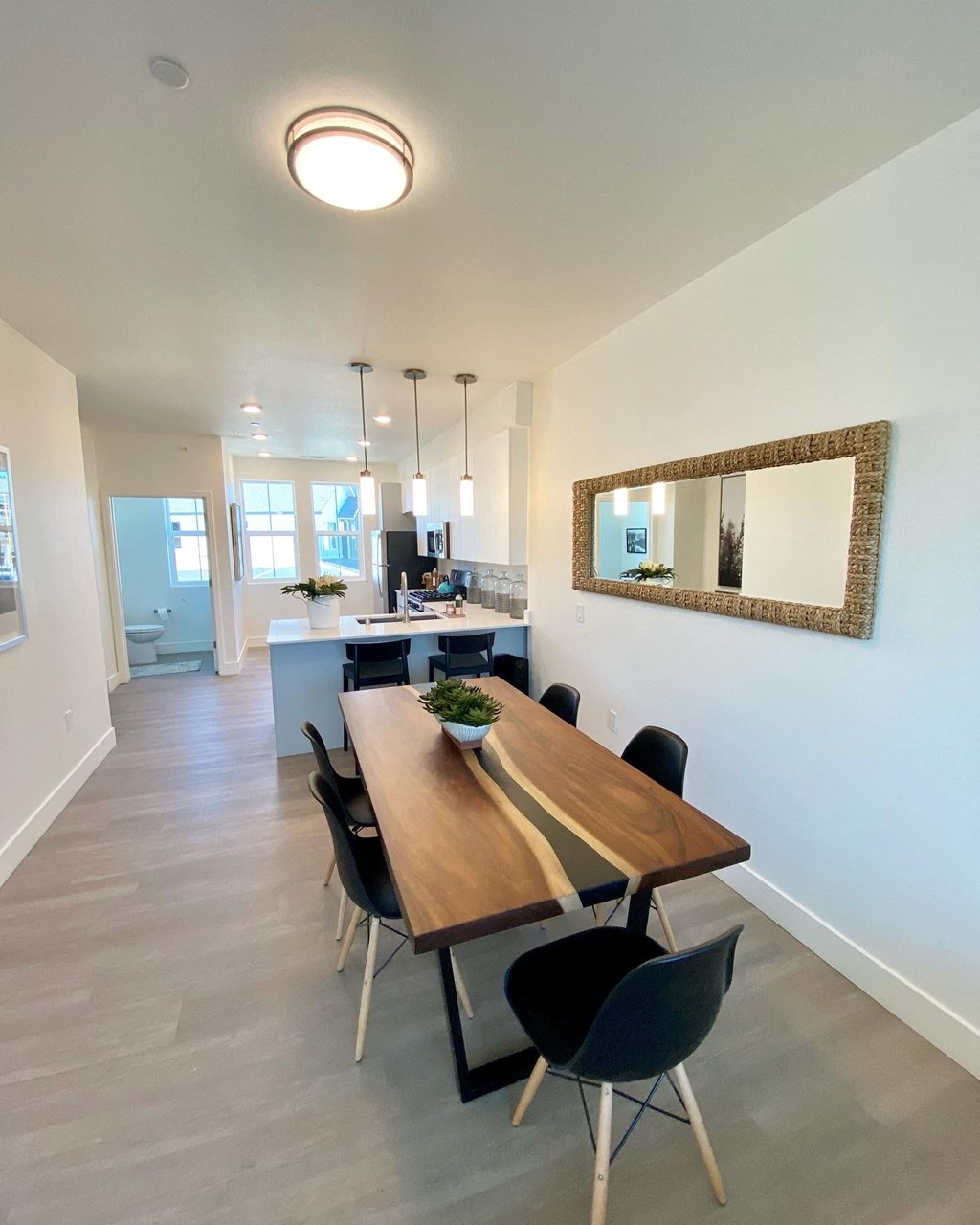 a dining room and kitchen area with a wooden table and chairs