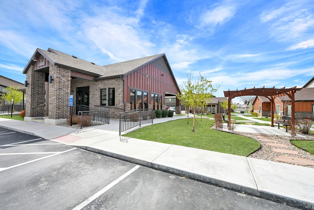 A building with a red roof and a wooden pergola in front.