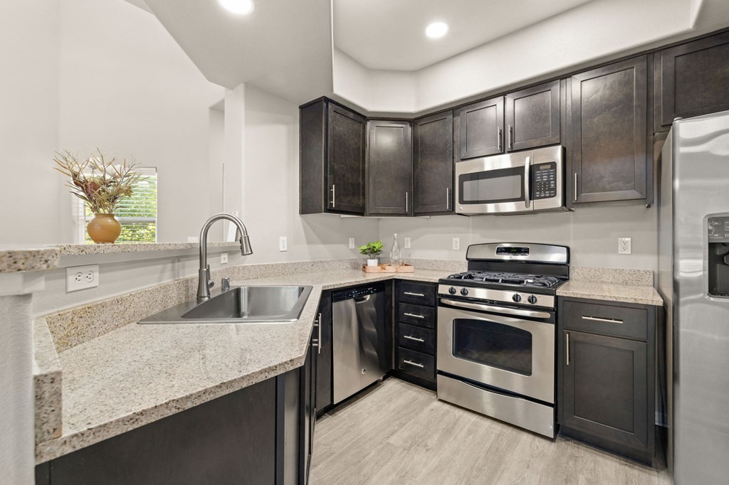 a kitchen with stainless steel appliances and granite counter tops
