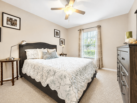 A bedroom with a large bed and a ceiling fan.