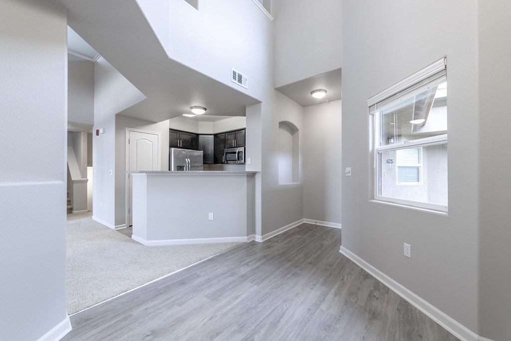 the living room and kitchen in a new home with a large window
