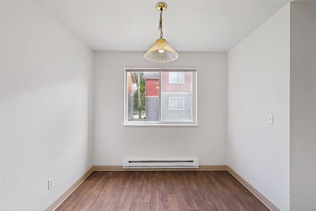 A room with a window and a hanging light fixture.at The Timbers by Vintage, Arlington, 98223