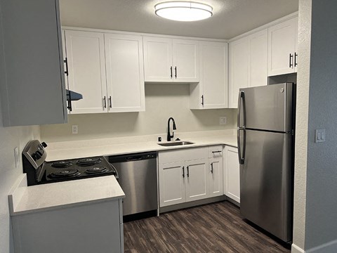 a kitchen with stainless steel appliances and white cabinets