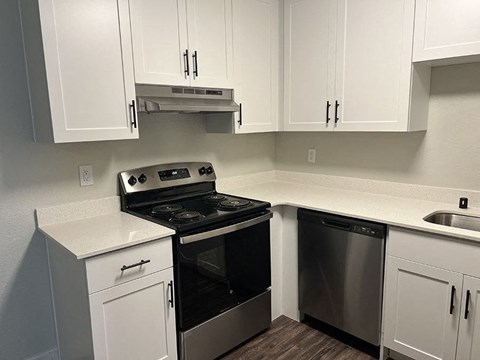 a kitchen with white cabinets and a black stove