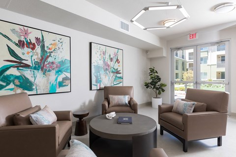 A living room with two couches, a coffee table, and two paintings on the wall.