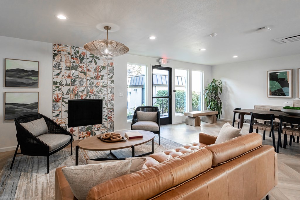 a living room with a couch and chairs and a tv
