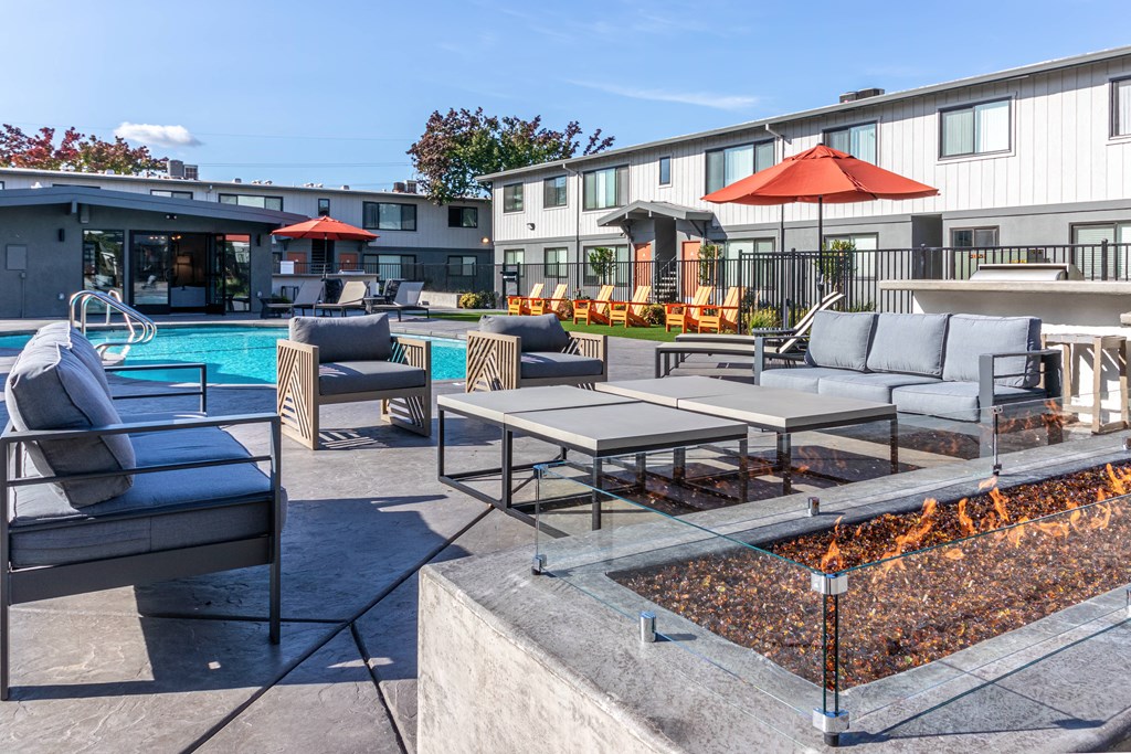 an outdoor patio with tables and chairs and a swimming pool