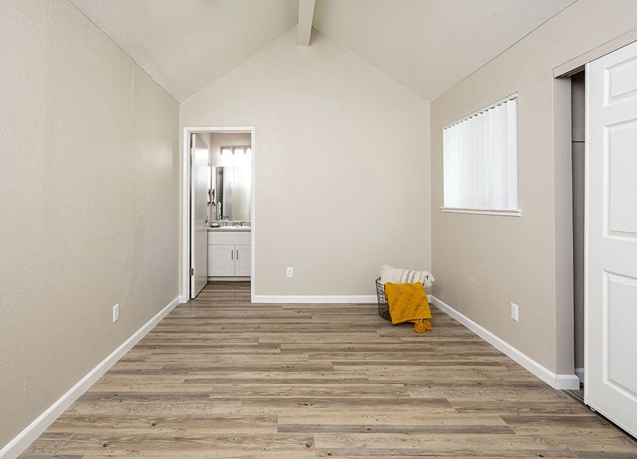 Pet-Friendly Apartments in Rohnert Park, CA - Americana - Bedroom with Bathroom Entrance, Sliding Closet Doors, and Large Window