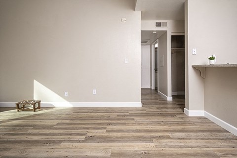 a living room and hallway with wood flooring and white walls