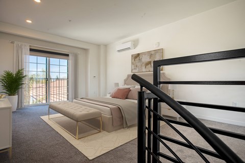 a bedroom with a bed and a stool near a window at THE ANGELINO, California