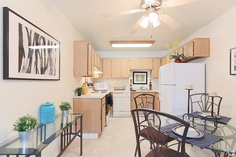 Ashford park kitchen and dining area with ceiling fan and light colored cabinets