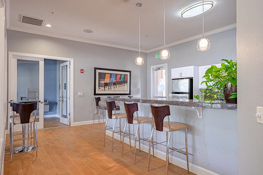 a kitchen with a bar and stools in a living room