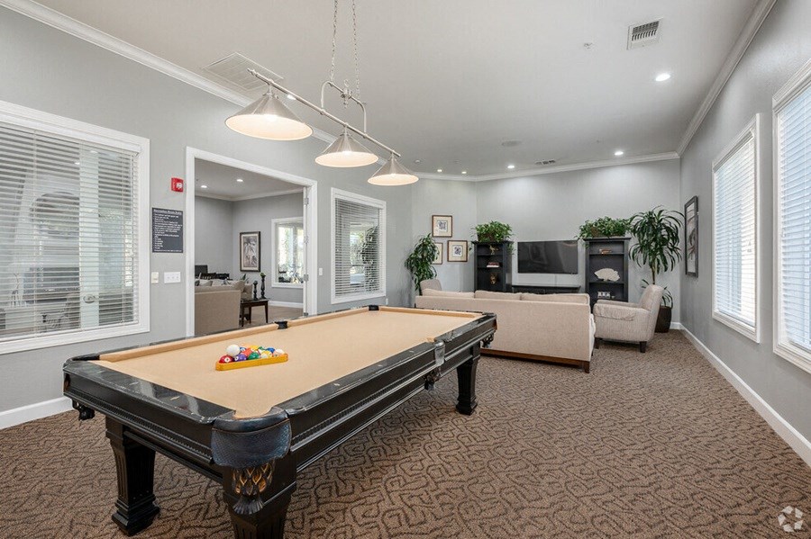 a game room with a pool table and a television