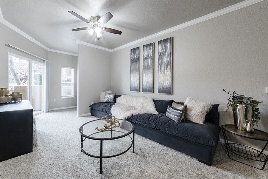 an open living room with a couch and a ceiling fan