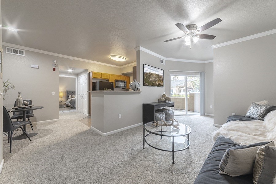 the living room and kitchen in a new home with a ceiling fan