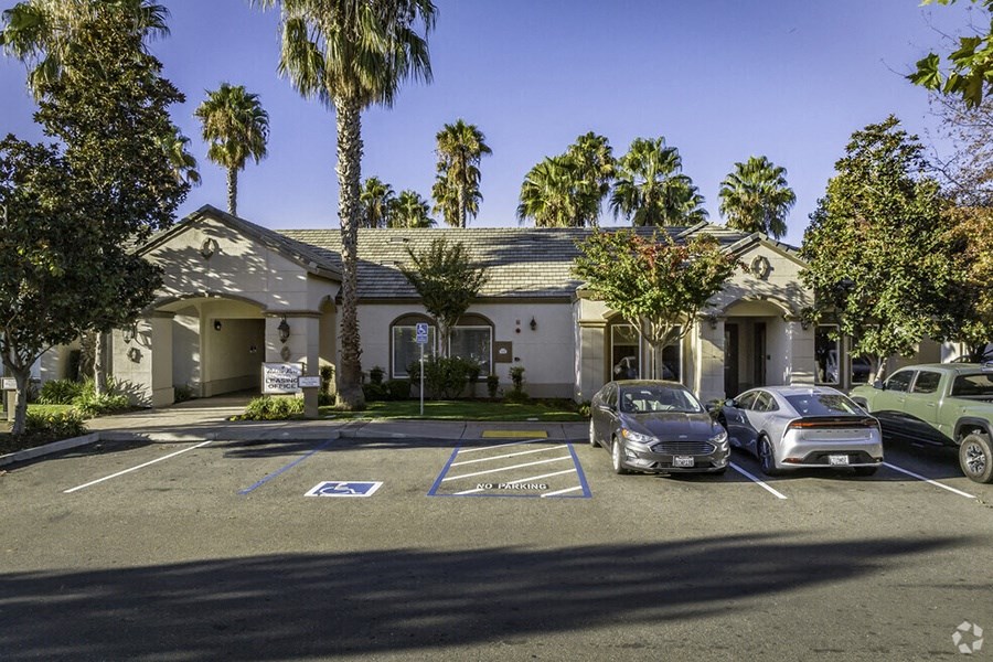 a house with a parking lot and cars in front of it
