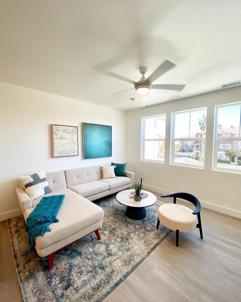 a living room with a white couch and a ceiling fan