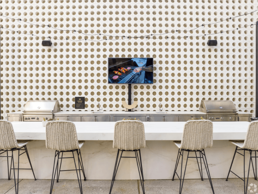 a long white table with four chairs in front of a wall