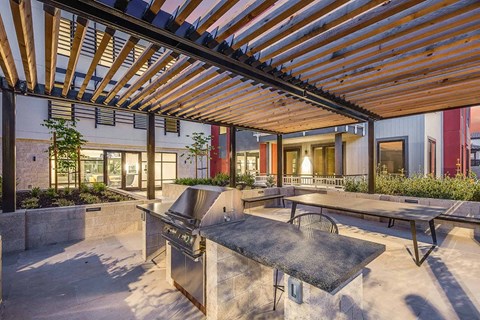 a patio with a grill and ping pong table