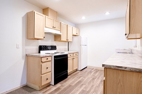 a kitchen with wooden cabinets and a black stove and refrigerator