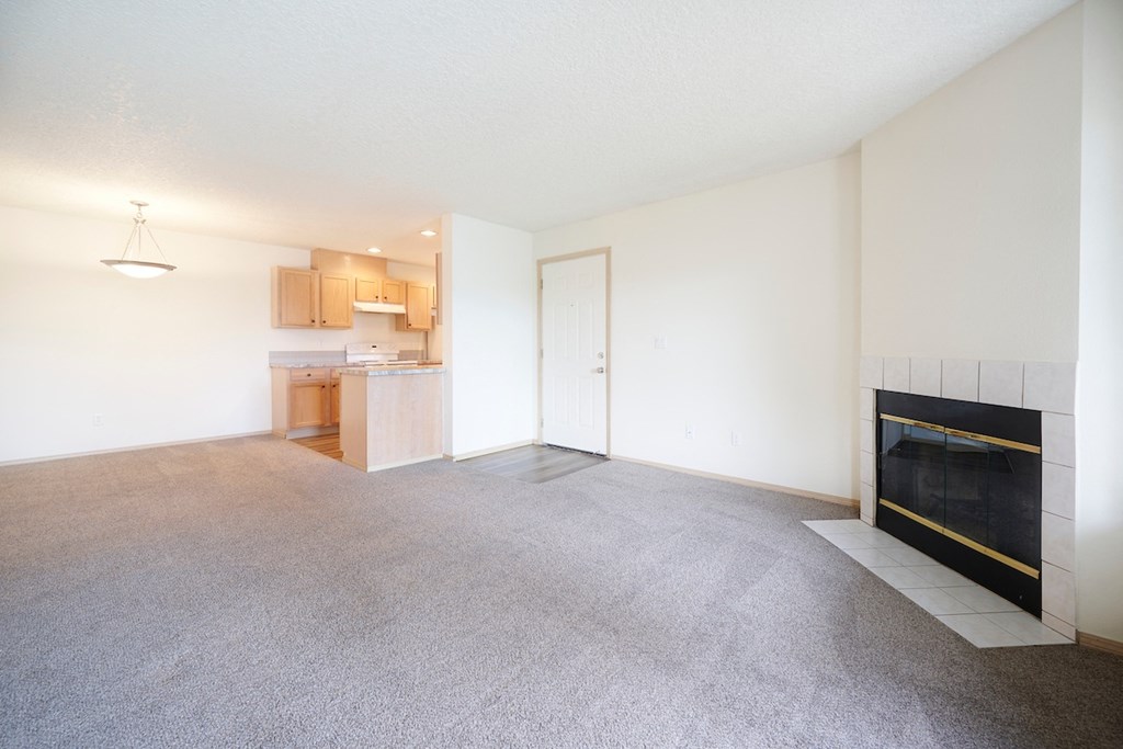 Living Room with Plush Carpeting and an Interior Fireplace at Devonwood and First Place Apartments, Battle Ground, 98604