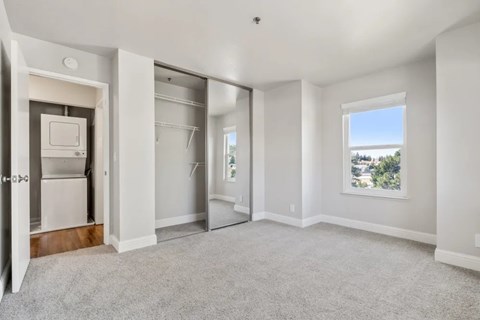 A spacious, empty room with a window overlooking a landscape.