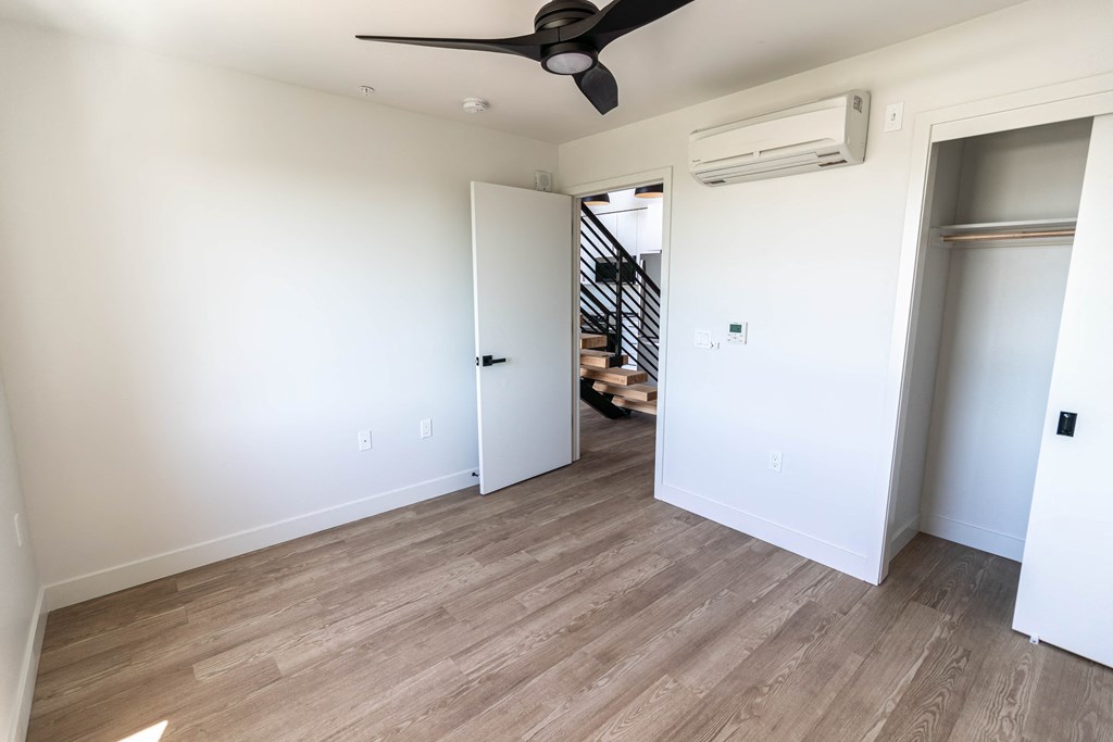 a renovated living room with white walls and a ceiling fan