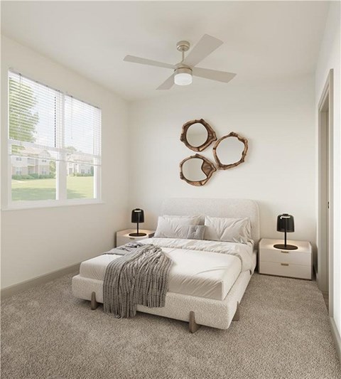 A bedroom with a large bed and a ceiling fan.