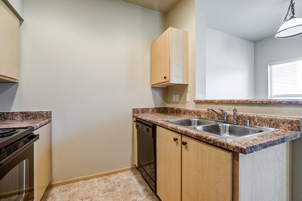 Kitchen with Wood Cabinets, Grey Walls, and Black Appliances at BELLA SONOMA, Fife, 98424