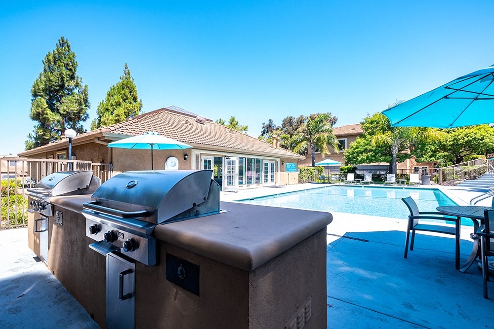 Richmond Apartments for Rent - Bella Vista at Hilltop - BBQ Area with Two Grills, Tables, Chairs, Umbrellas, and a Pool