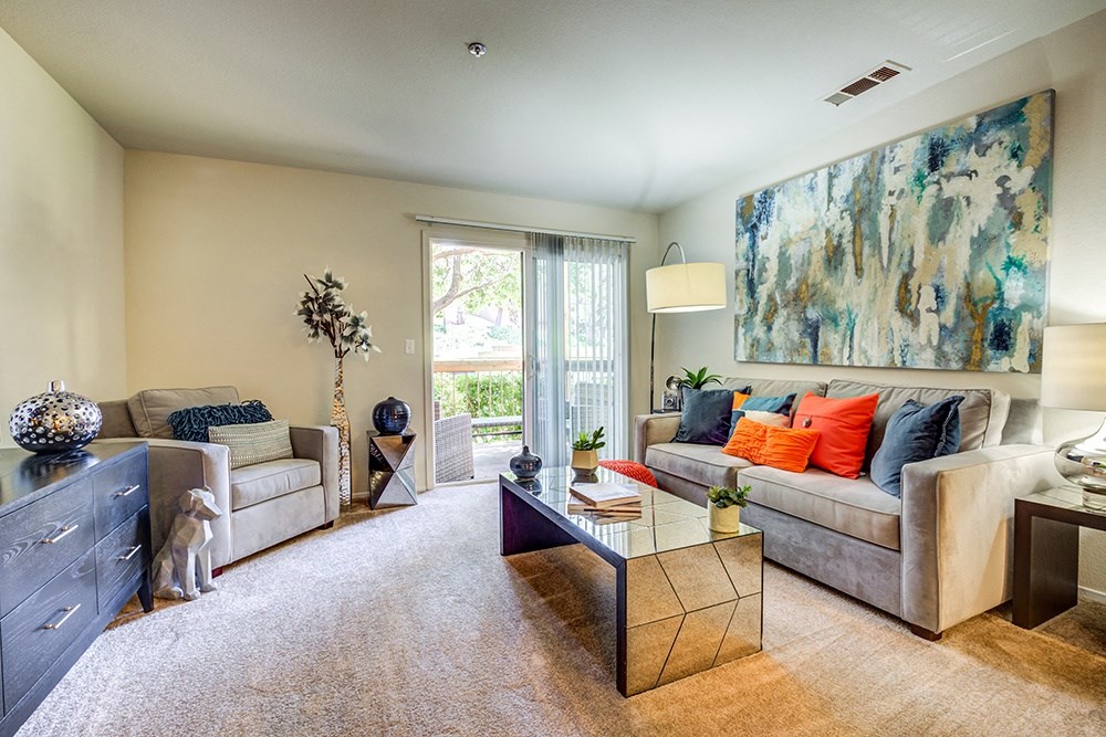 Pet-Friendly Apartments in Richmond CA - Bella Vista at Hilltop - Living Room with Fireplace, Plush Carpeting, and Attached Private Patio