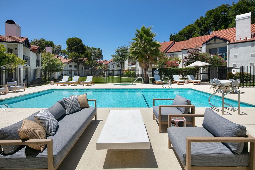 Outdoor Pool With Crystal Clear Water, Lounge Chairs, and Additional Cushioned Seating With a Table at Laurel Creek, Fairfield, 94533