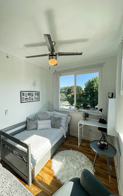a bedroom with a bed and a ceiling fan