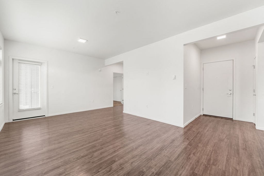 a bedroom with hardwood floors and white walls