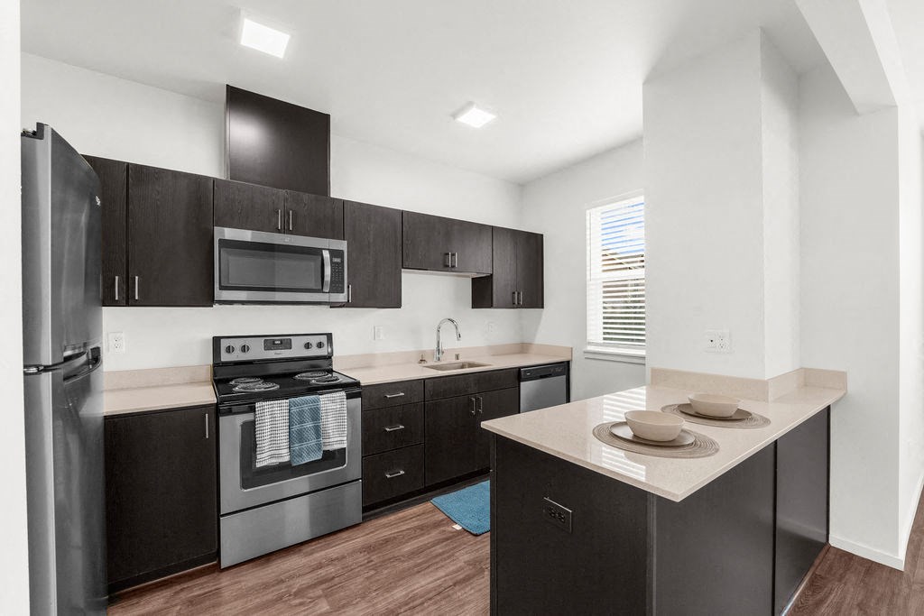 a kitchen with dark wood cabinetry and stainless steel appliances