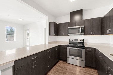 a kitchen with dark cabinets and white countertops