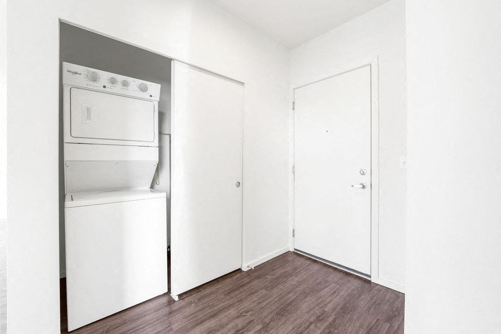 a white room with a white refrigerator and a white washer and dryer