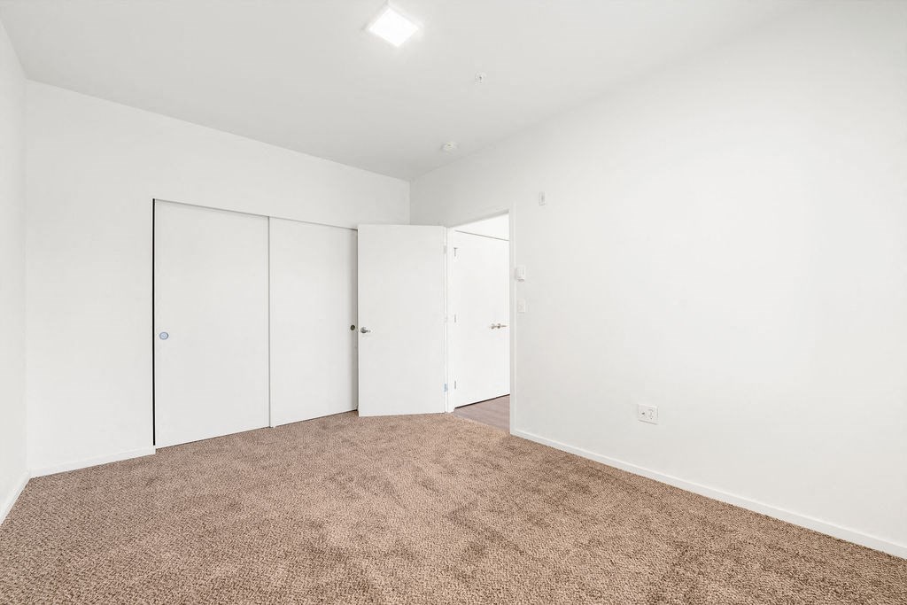 a bedroom with white walls and carpet
