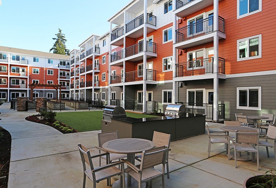 Senior Apartments In Arlington - Outdoor Seating Courtyard With BBQ Grills And Tables And Chairs