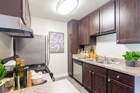 A kitchen with brown cabinets and a stove top oven.
