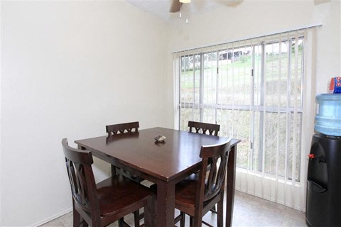 A dining room with a wooden table and chairs.