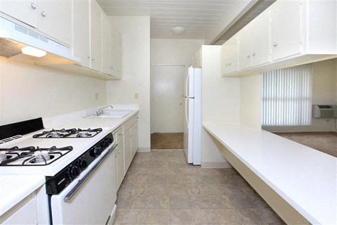 A white kitchen with a black stove top.