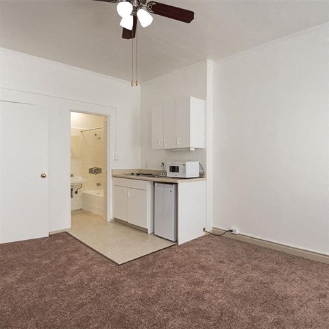 an empty kitchen with a microwave and a sink