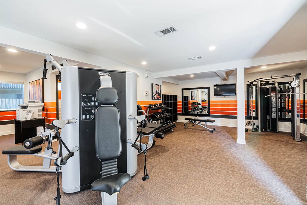 a gym with various machines and chairs in a room