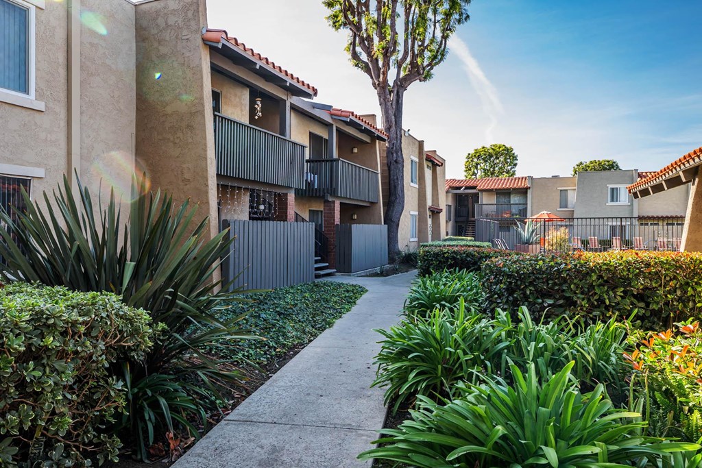 a walkway between two apartment buildings with a sidewalk